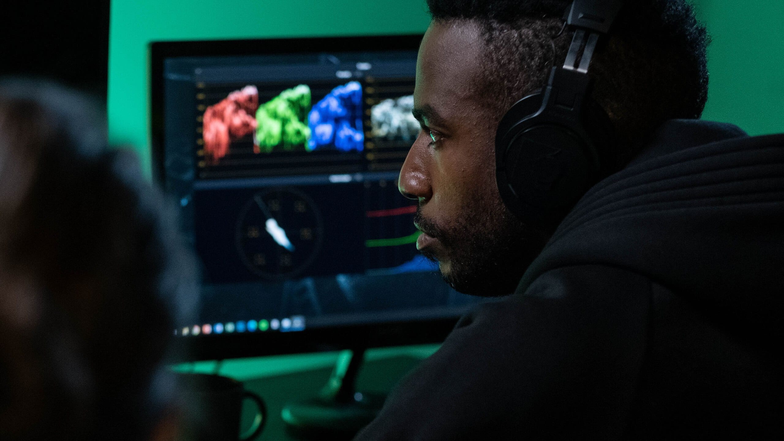 A colourist at a grading suite, colour scopes and a graded frame on the monitors